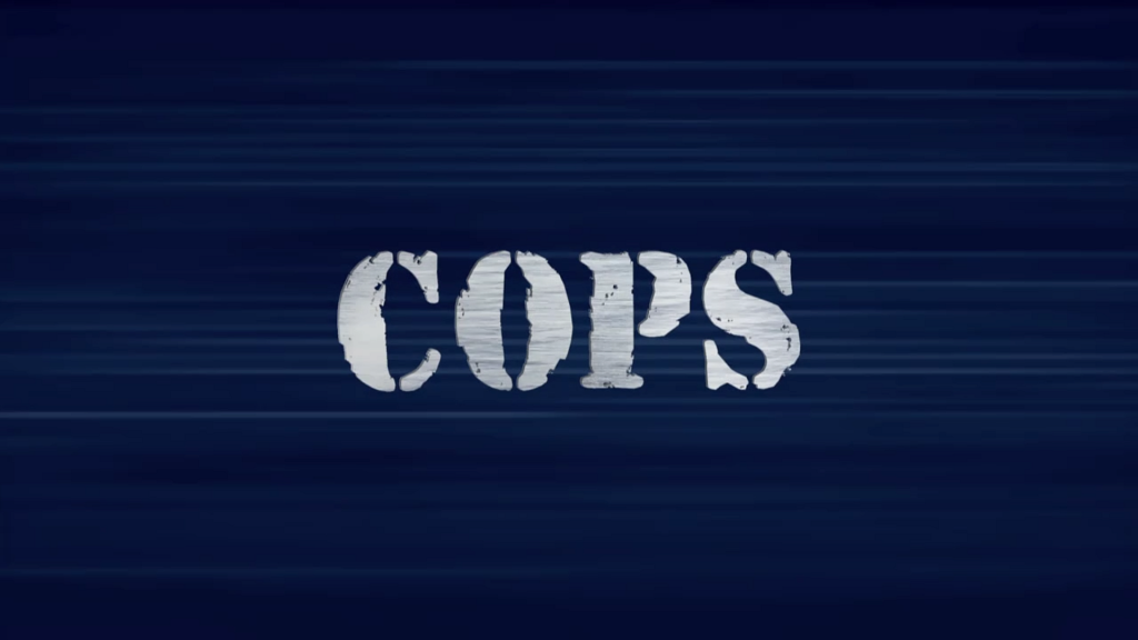 Logo of the TV show "COPS. The letters C-O-P-S are shown in roughly finished gunmetal grey against a dark blue, striated background.